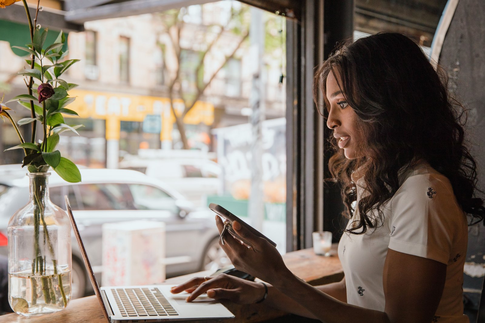 A café owner checking her phone behind the counter in the morning